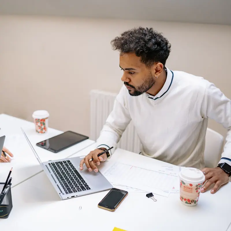A recruiter working through applications on a laptop at a bright office desk